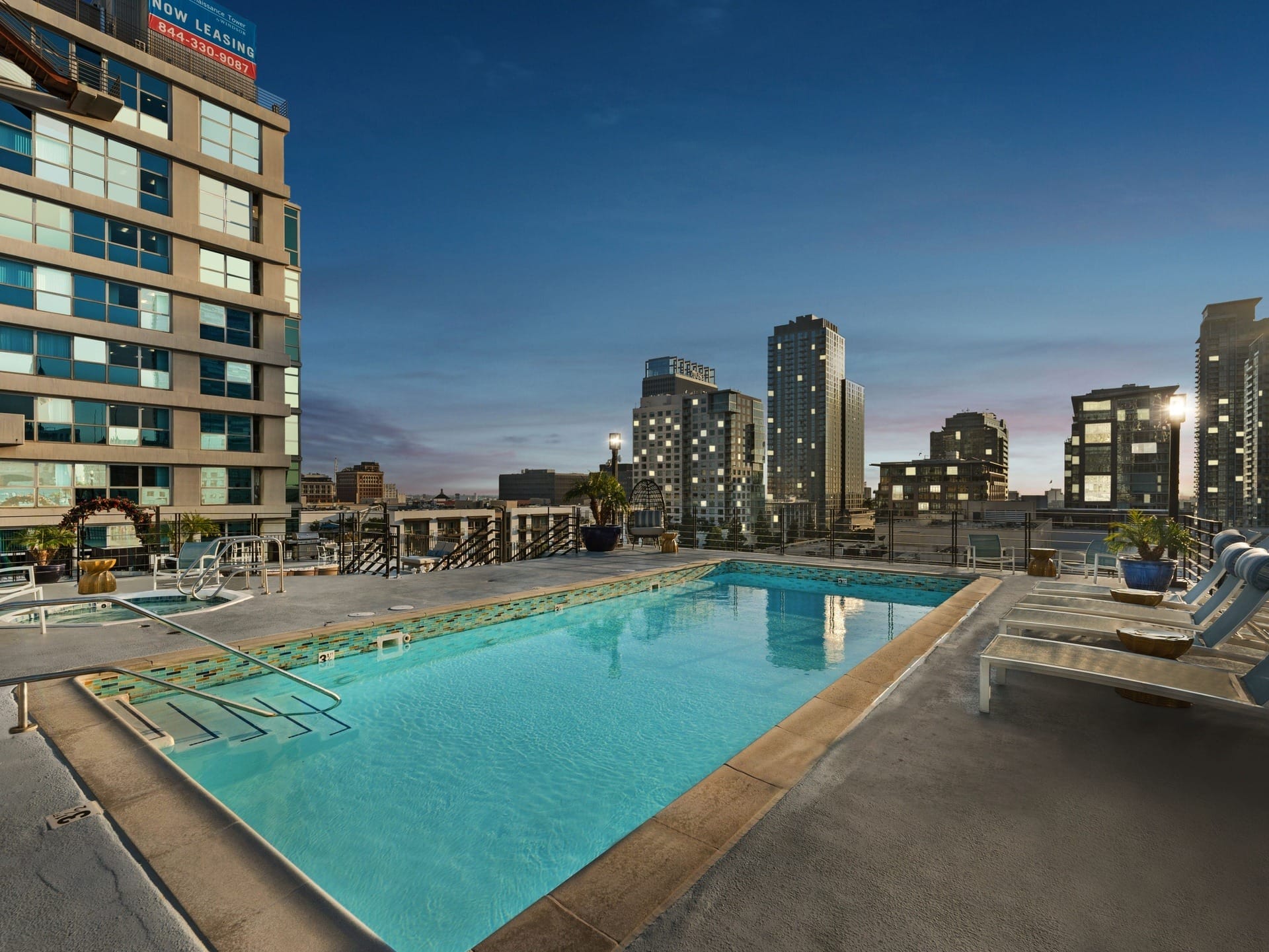 a pool with a city skyline in the background at night