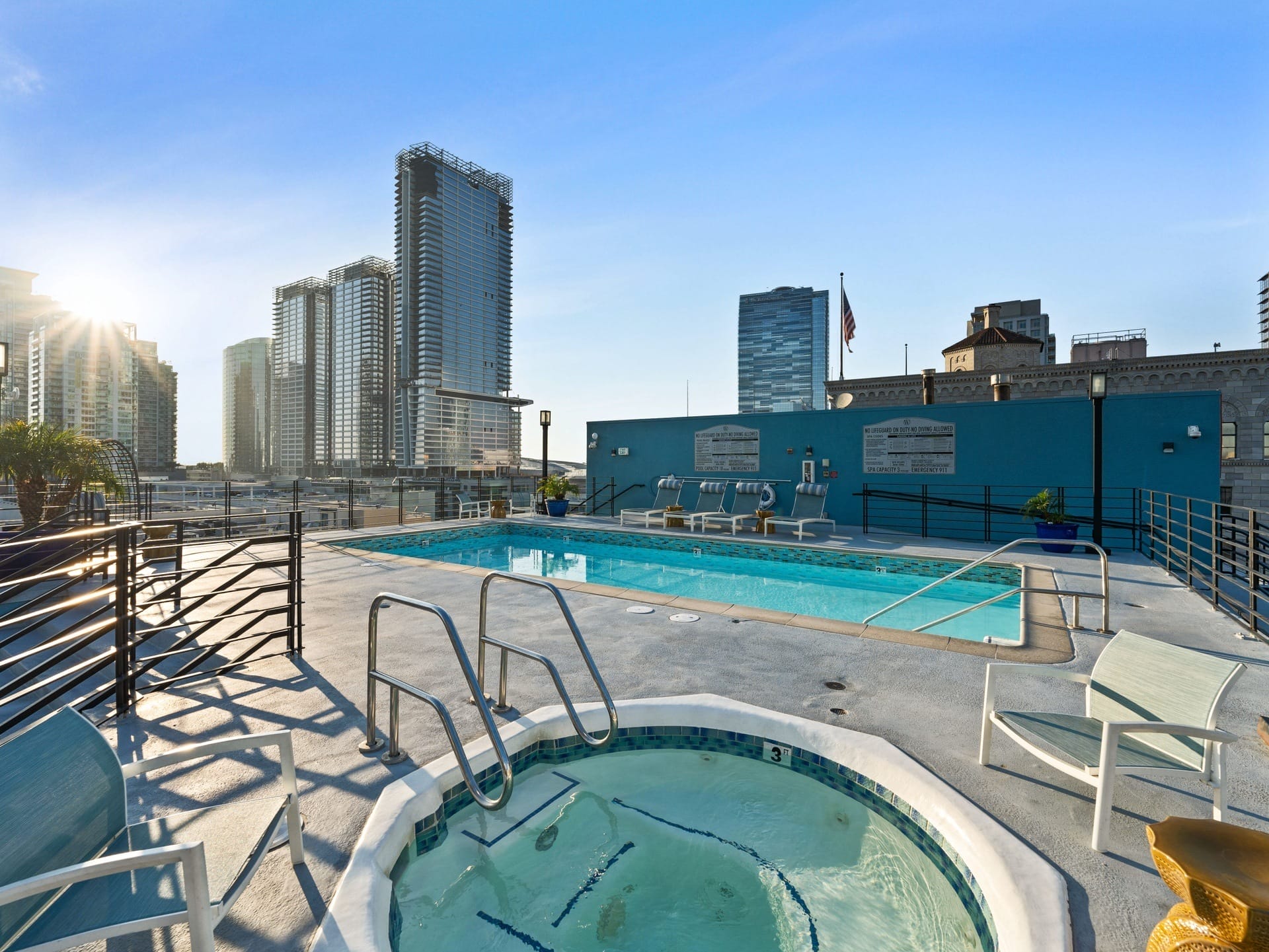 a pool on the roof of a building with a city in the background