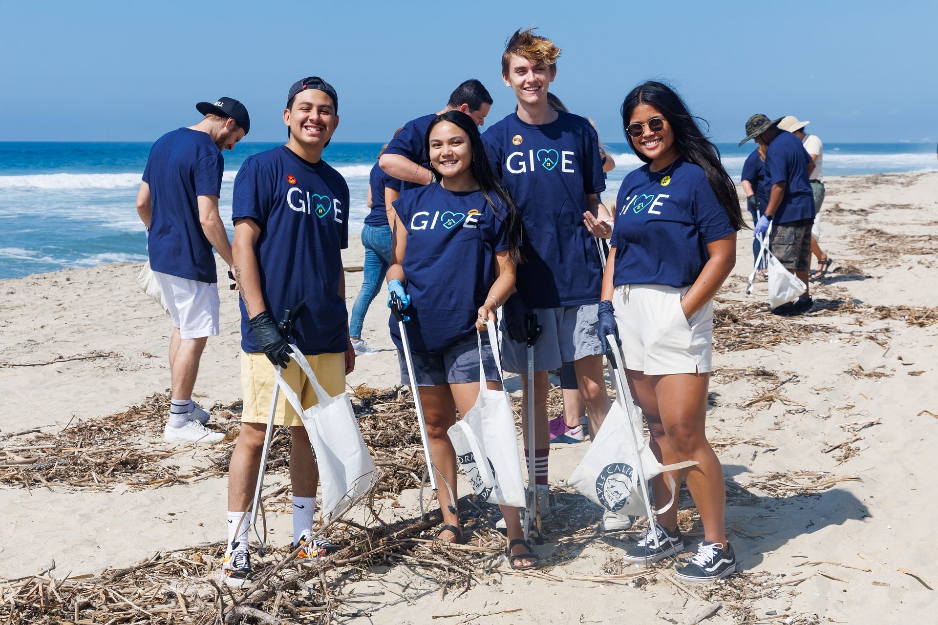 a group of volunteers posing for a photo on the beach.