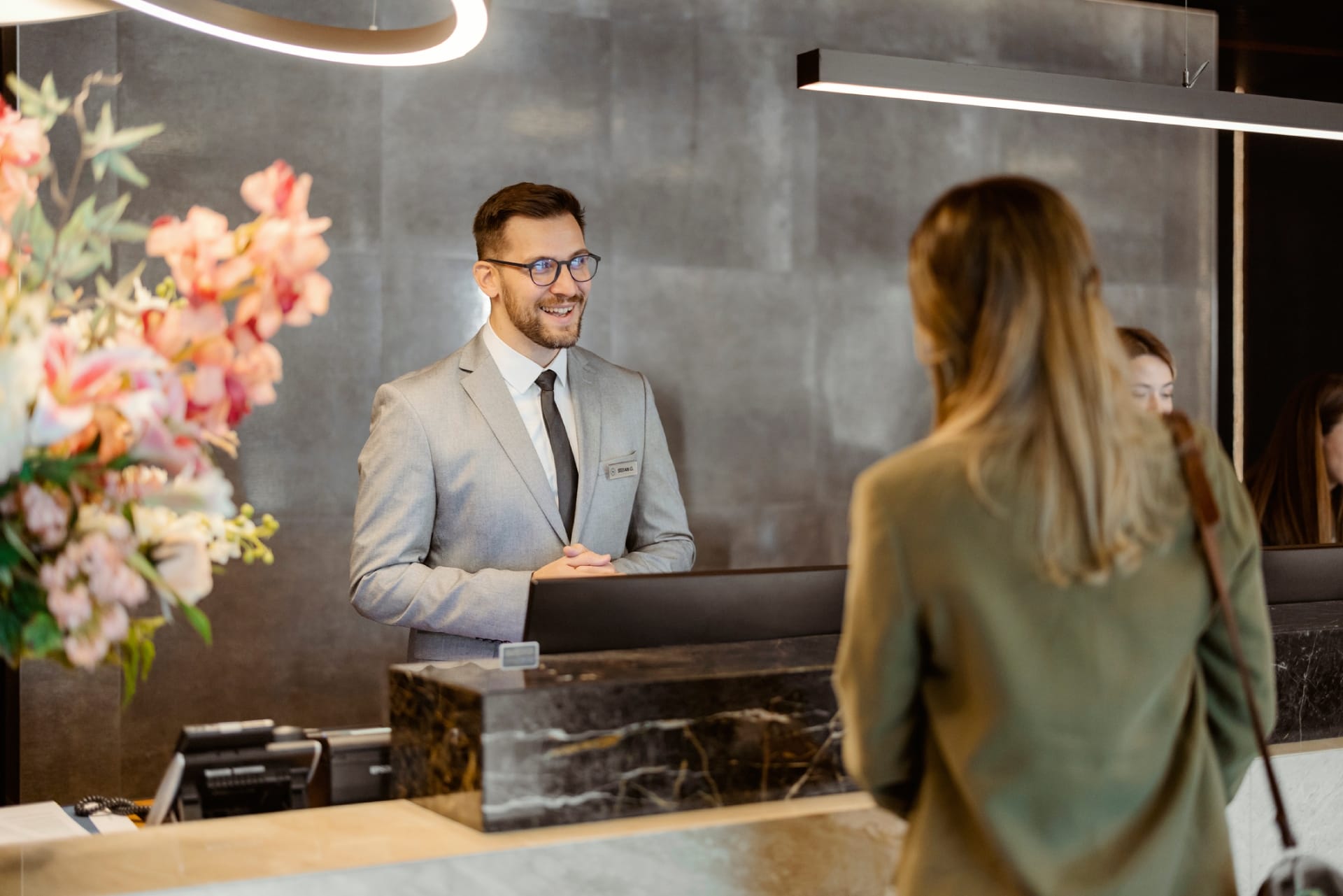 Male receptionist at front office talking with guest in hotel